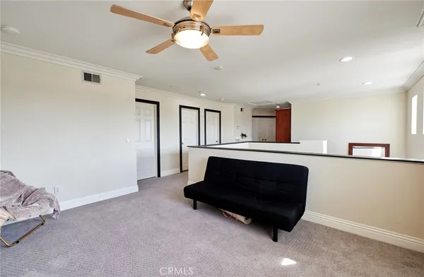 a living room with furniture and a ceiling fan