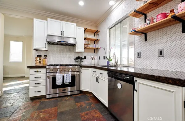 a large kitchen with stainless steel appliances a sink and a stove
