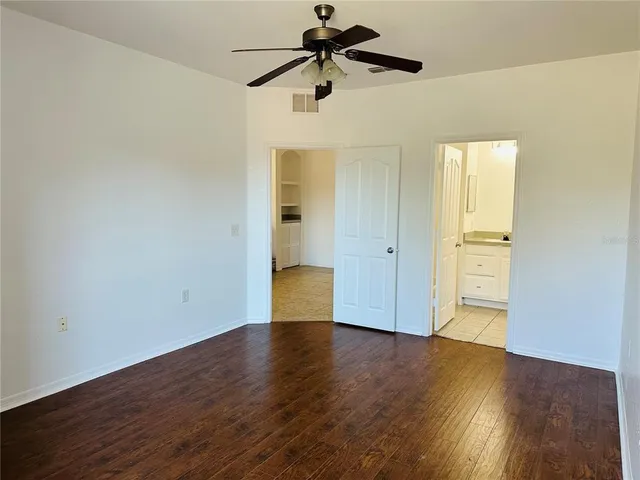 a view of a livingroom with wooden floor and a ceiling fan