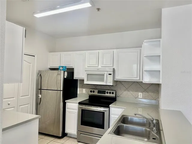 a kitchen with a refrigerator stove and cabinets