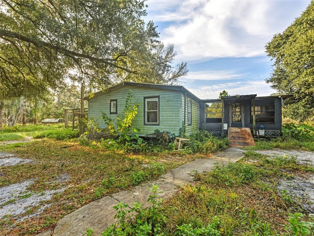 7275 Knowles Road Polk City, FL 33868 - Photo 1 of 39 a yellow house with trees in front of it