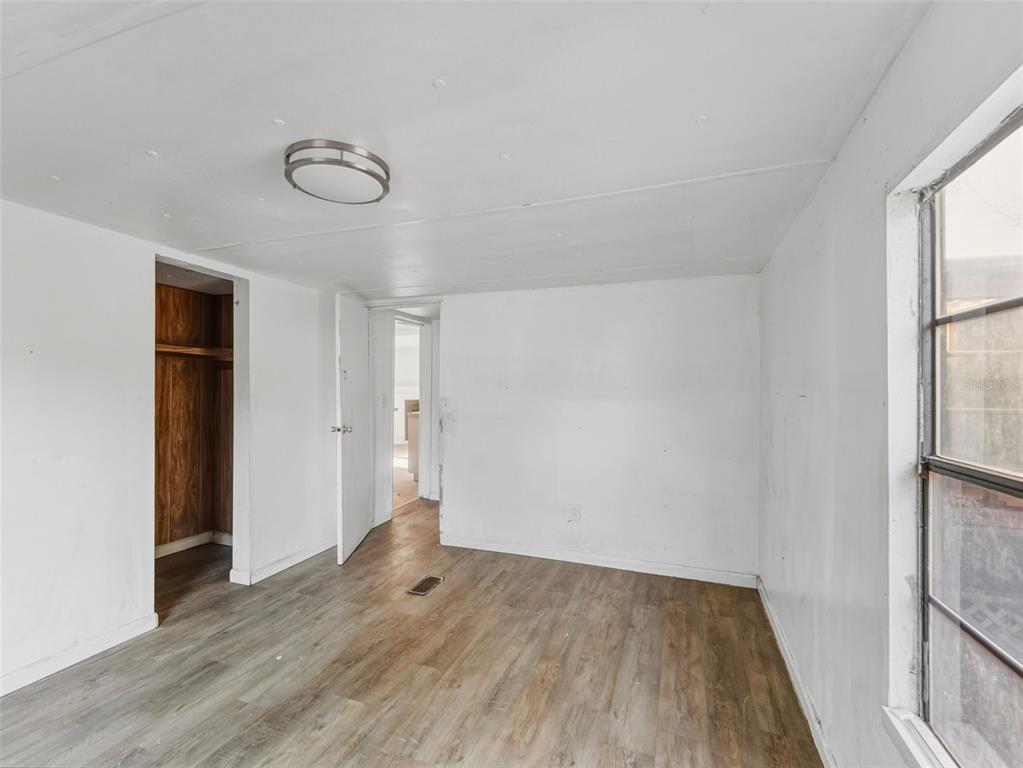 7275 Knowles Road Polk City, FL 33868 - Photo 11 of 39 an empty room with wooden floor and windows