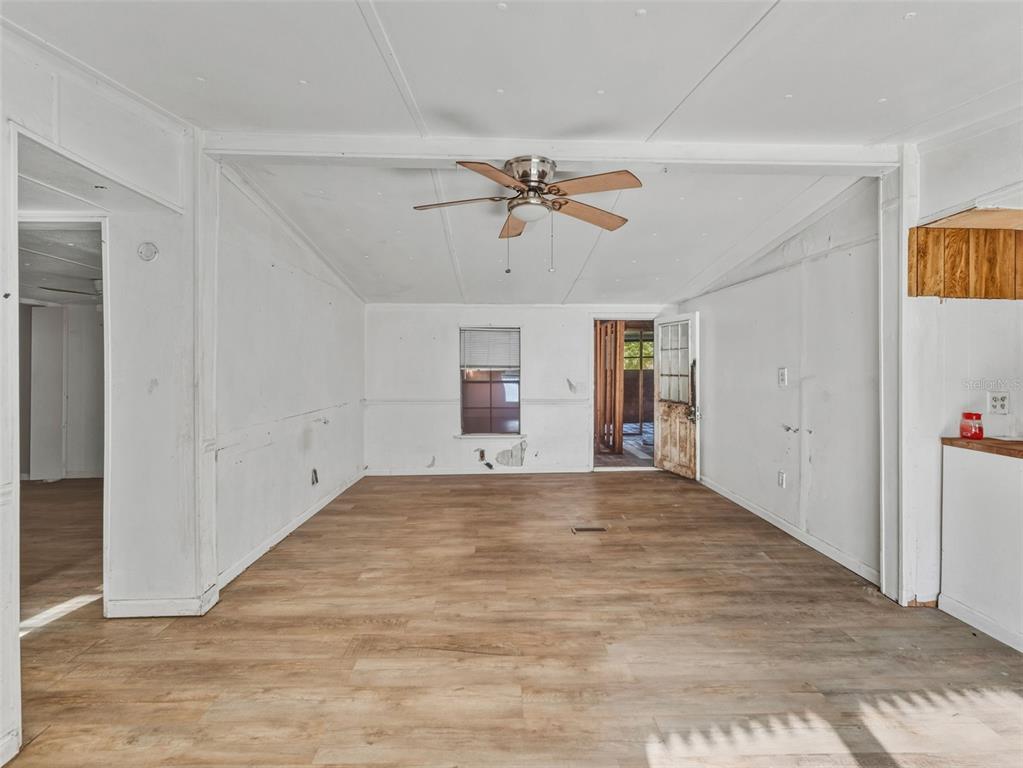 7275 Knowles Road Polk City, FL 33868 - Photo 5 of 39 a view of empty room with wooden floor and ceiling fan