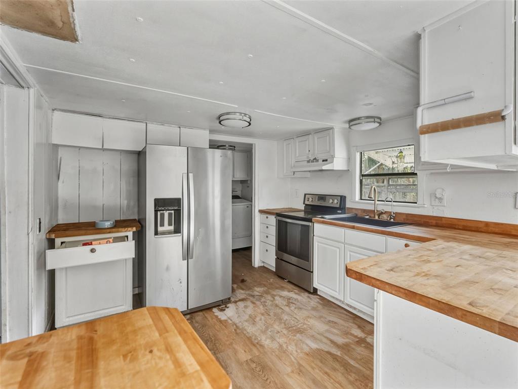 7275 Knowles Road Polk City, FL 33868 - Photo 7 of 39 a kitchen with granite countertop a refrigerator and a stove top oven