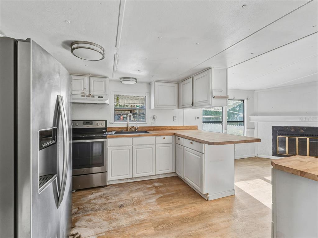 7275 Knowles Road Polk City, FL 33868 - Photo 9 of 39 a kitchen with granite countertop a refrigerator stove top oven and sink