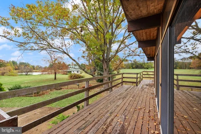 a large dining hall with stainless steel appliances granite countertop a coffee table and a bookshelf with wooden floor