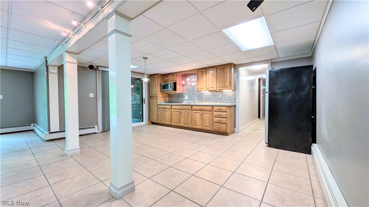 6409 Old Woods Road Ashtabula, OH 44004 - Photo 20 of 43 Spacious lower-level area featuring light-toned square tile flooring, a drop ceiling with integrated lighting, and a built-in kitchenette