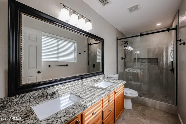a bathroom with a granite countertop sink toilet and shower