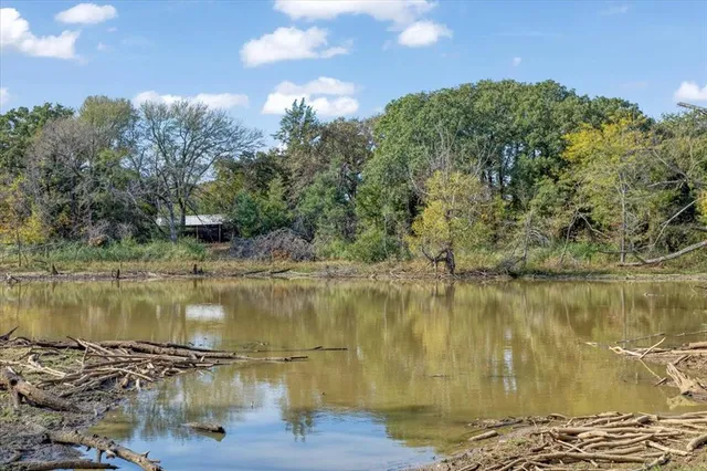 an aerial view of residential houses with outdoor space and trees