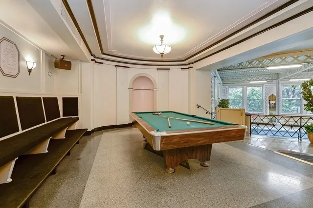 a room with furniture pool table and windows