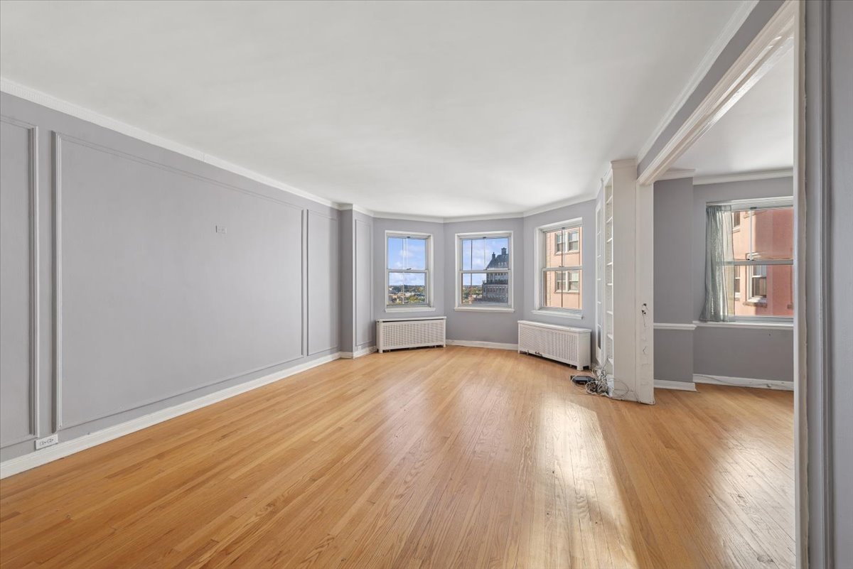 5555 North Sheridan Road, Unit 1504 Chicago, IL 60640 - Photo 4 of 18 an empty room with wooden floor and windows