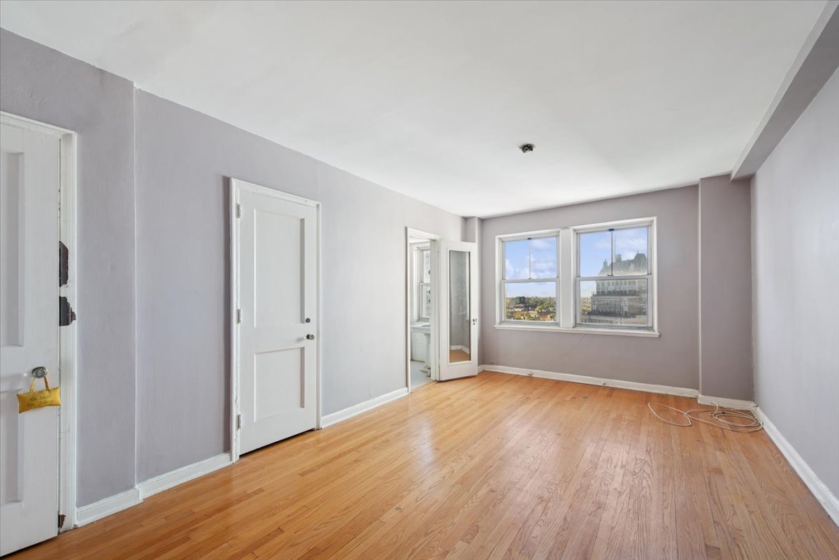 5555 North Sheridan Road, Unit 1504 Chicago, IL 60640 - Photo 7 of 18 a view of empty room with wooden floor and fan