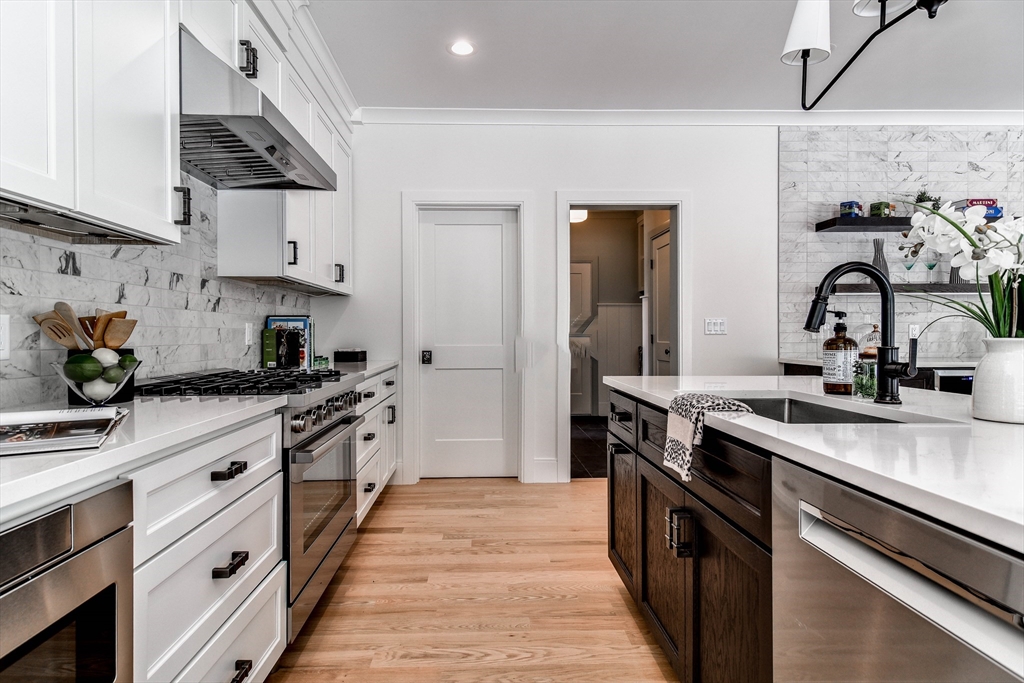 1 Winter Street Natick, MA 01760 - Photo 12 of 26 a kitchen with stainless steel appliances granite countertop a sink stove and cabinets