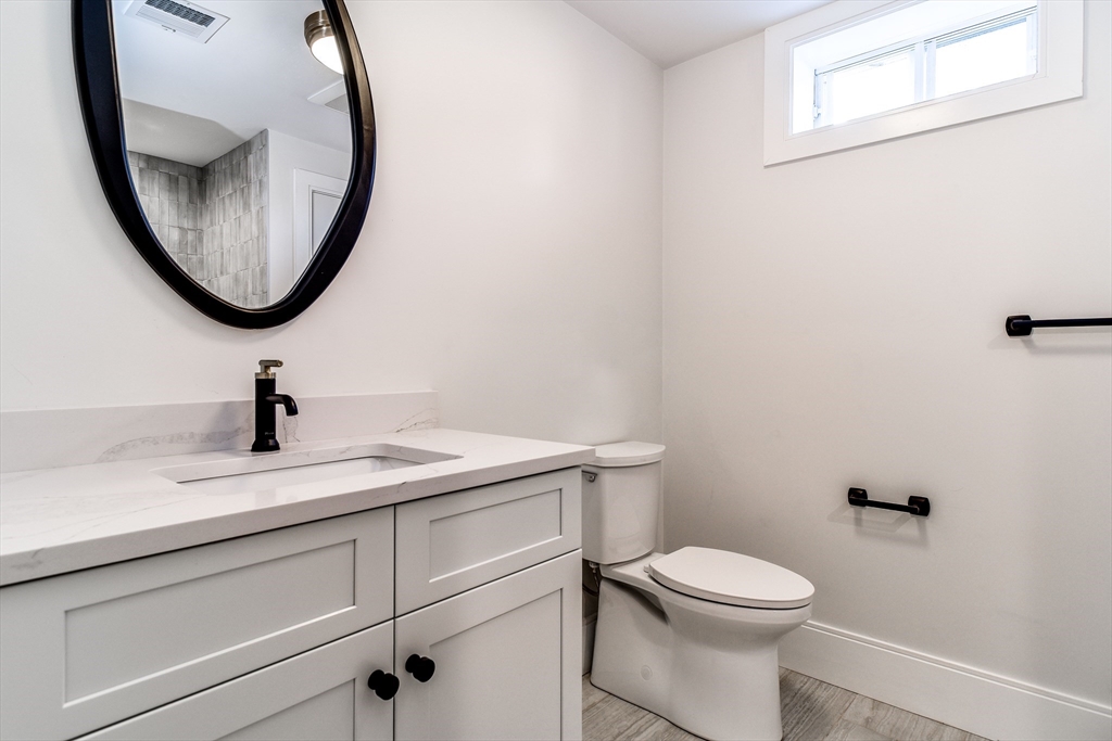1 Winter Street Natick, MA 01760 - Photo 22 of 26 a bathroom with a toilet a sink and a mirror