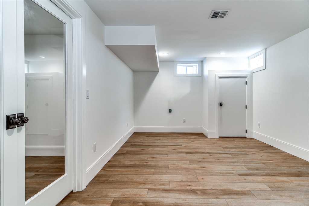 1 Winter Street Natick, MA 01760 - Photo 25 of 26 a view of a hallway with wooden floor and a bathroom