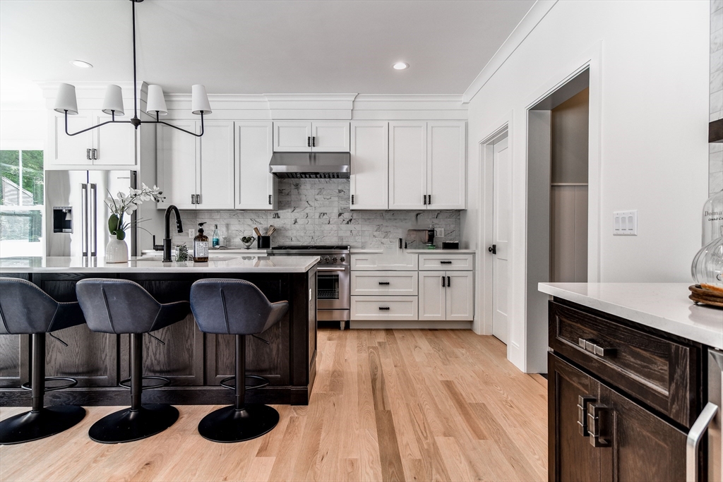 1 Winter Street Natick, MA 01760 - Photo 10 of 26 a kitchen with stainless steel appliances kitchen island granite countertop a sink dishwasher a stove a refrigerator and cabinets with wooden floor