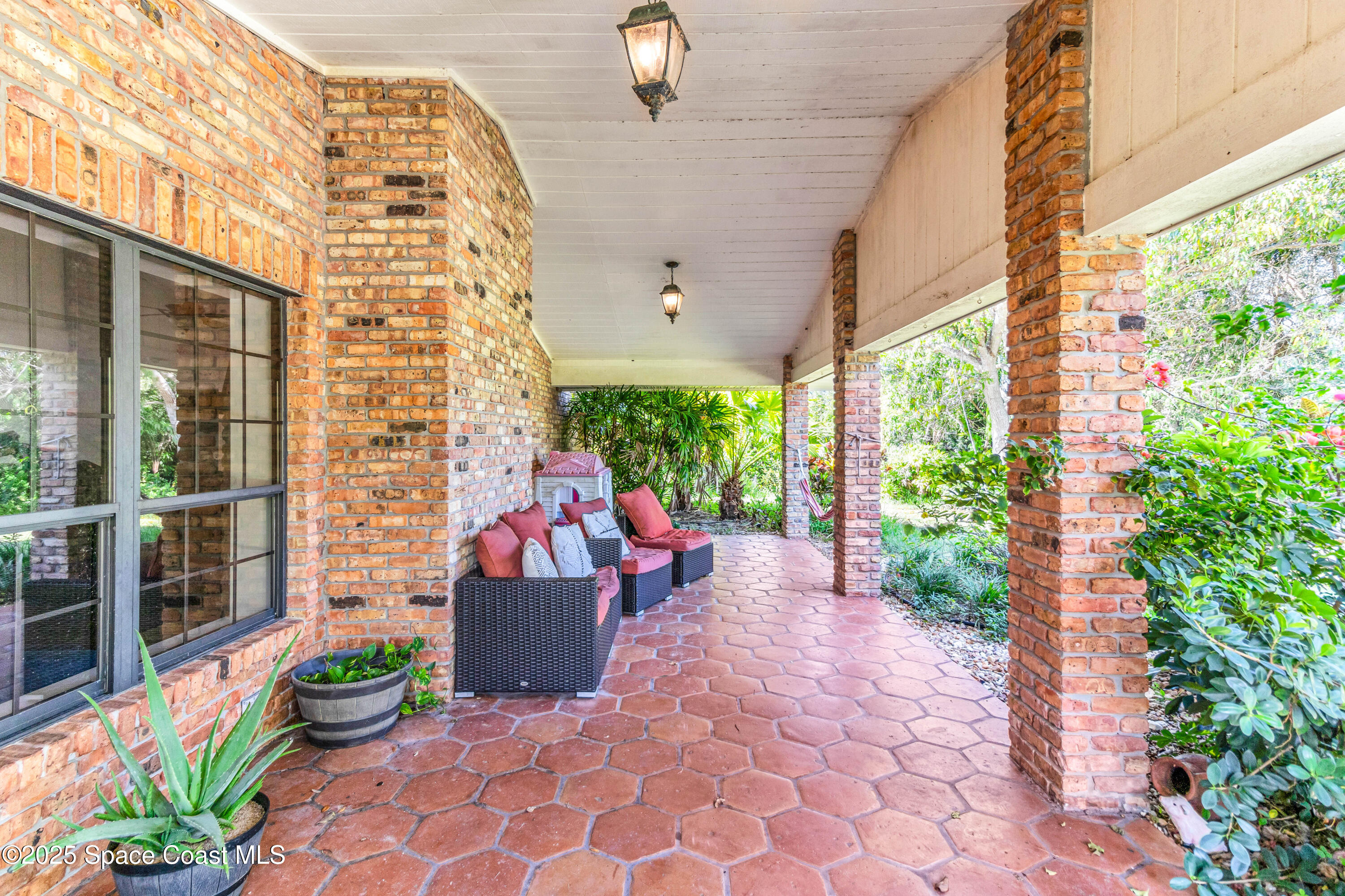 1980 Corey Road Malabar, FL 32950 - Photo 16 of 42 a view of a chairs and table in the patio with potted plants