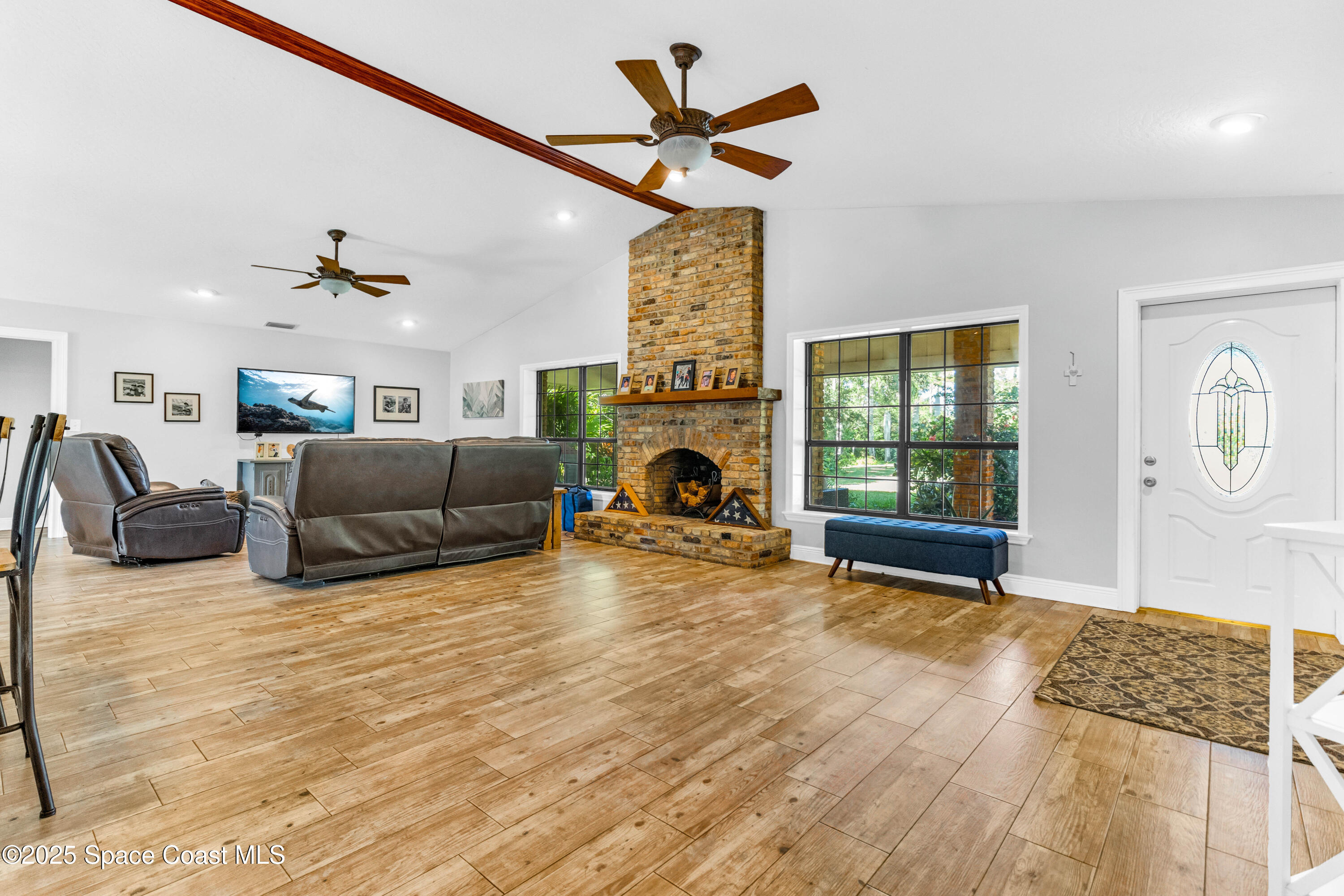 1980 Corey Road Malabar, FL 32950 - Photo 19 of 42 a living room with furniture a fireplace and a flat screen tv