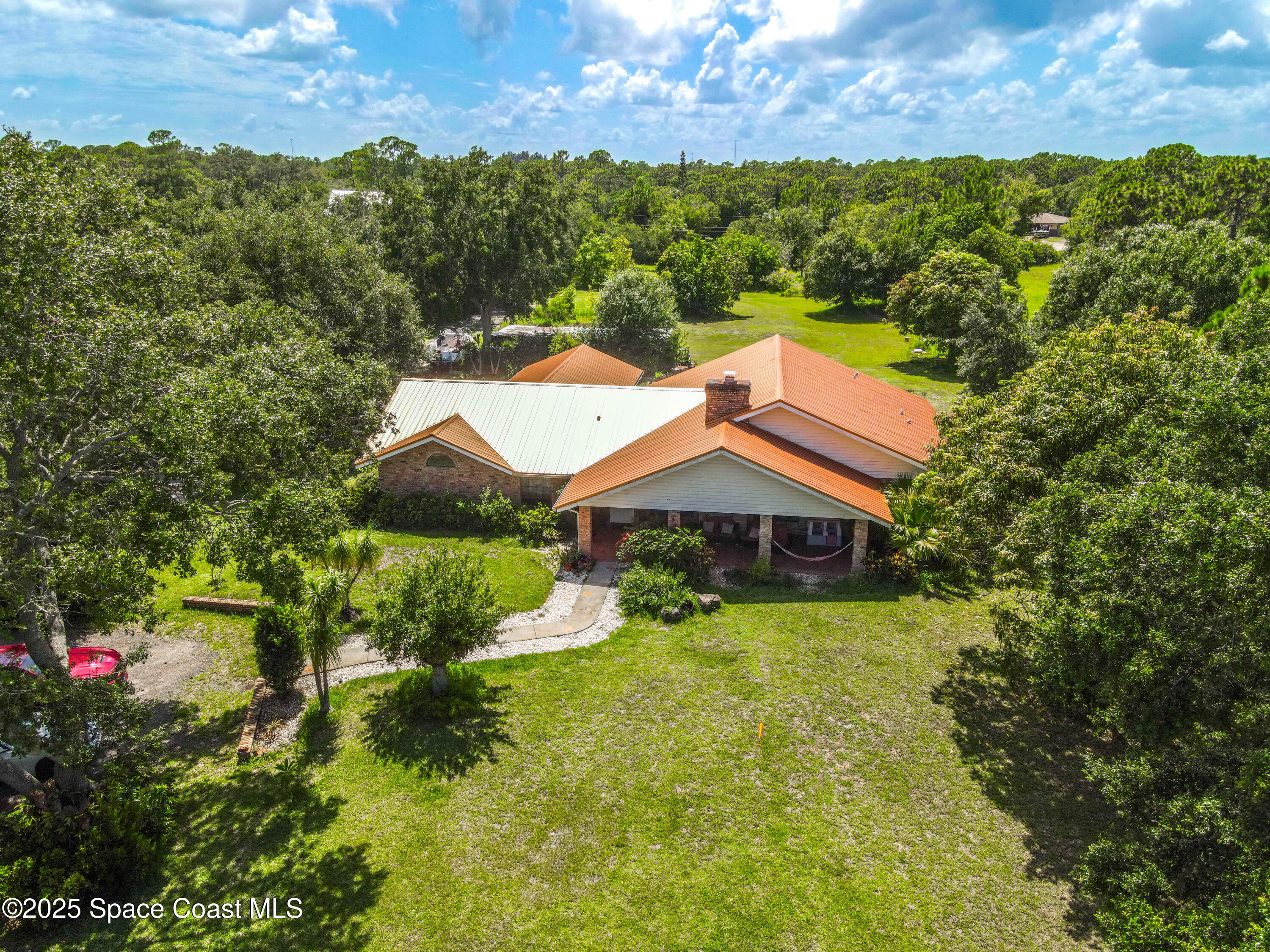 1980 Corey Road Malabar, FL 32950 - Photo 2 of 42 a view of a house with a big yard and large trees