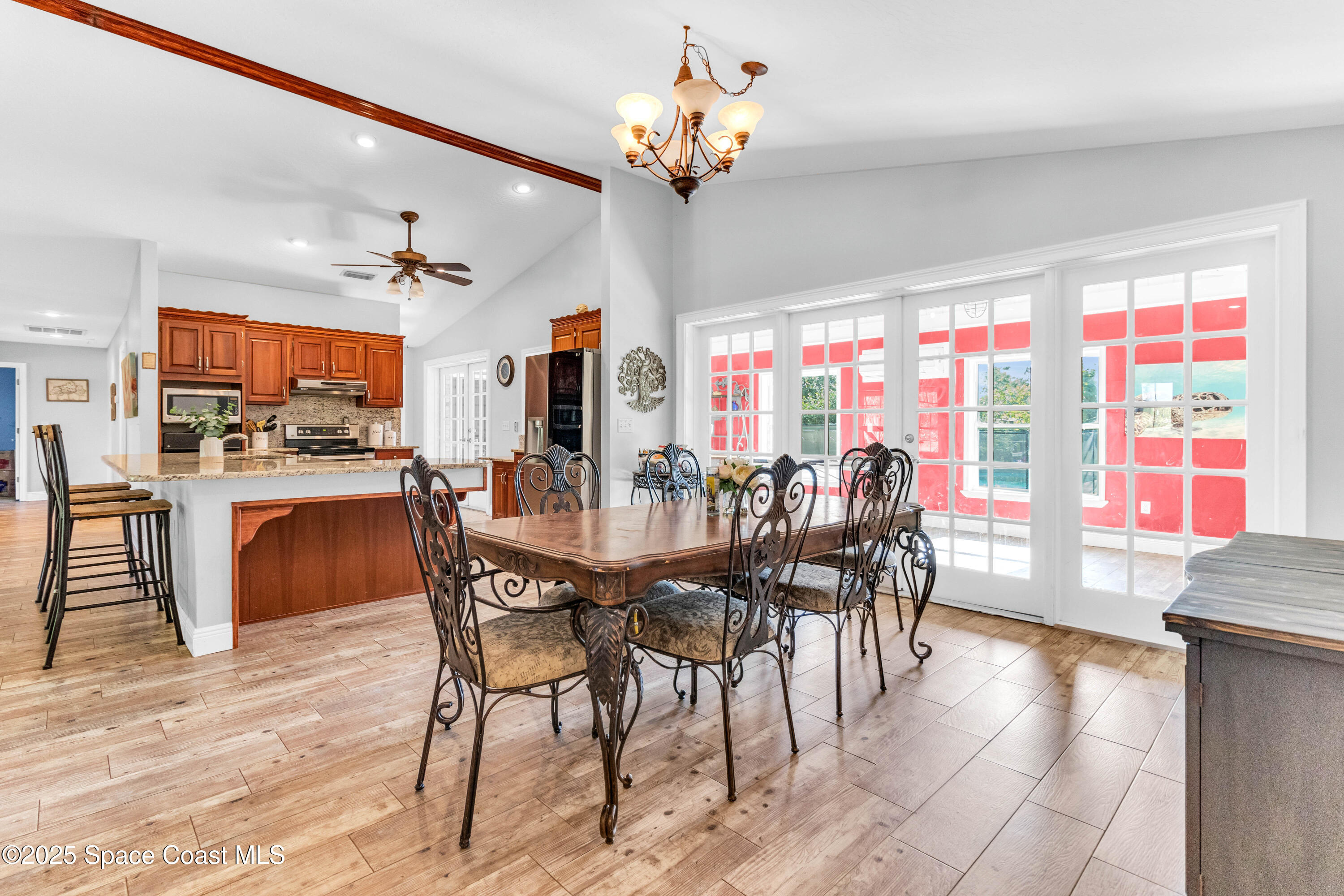 1980 Corey Road Malabar, FL 32950 - Photo 23 of 42 a dining area with furniture a chandelier and kitchen view