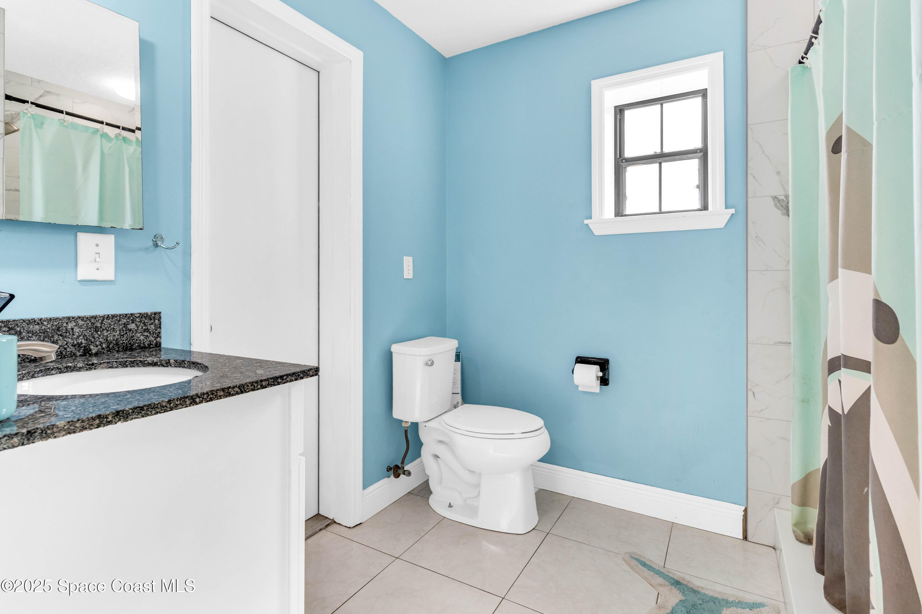 1980 Corey Road Malabar, FL 32950 - Photo 29 of 42 a bathroom with a granite countertop sink and a toilet