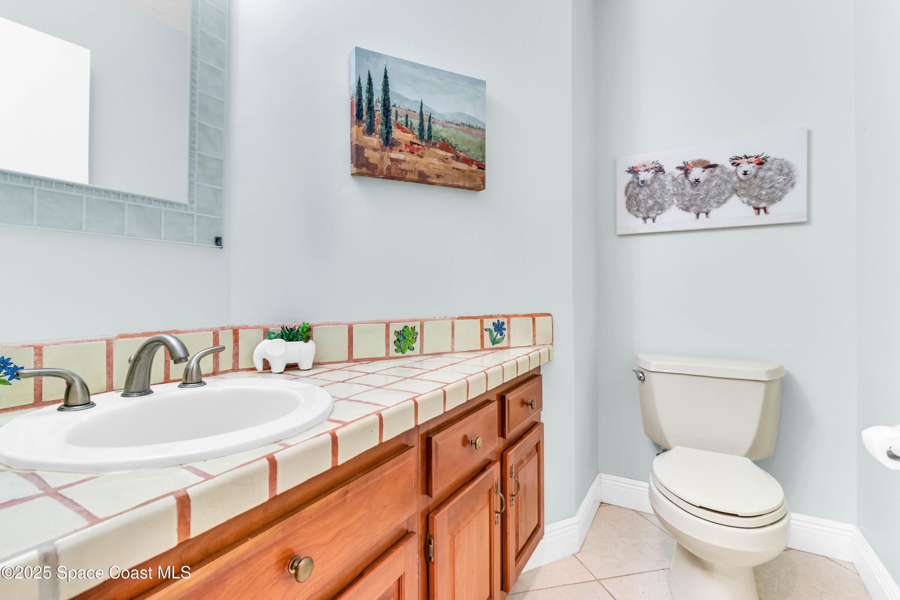1980 Corey Road Malabar, FL 32950 - Photo 32 of 42 a bathroom with a sink a toilet and a mirror