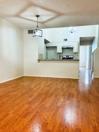 a view of empty room with wooden floor and window