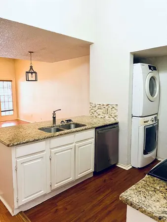 a kitchen with granite countertop white cabinets and white appliances