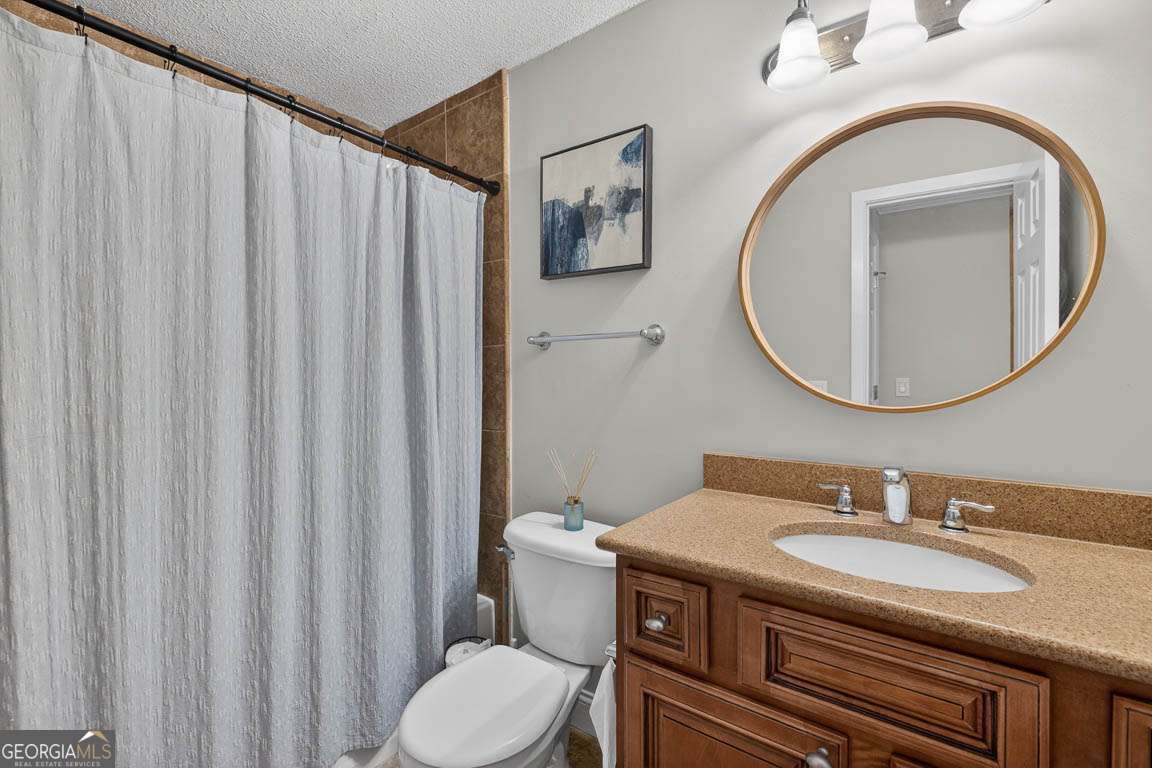 2514 Demere Road, Unit 7 St. Simons, GA 31522 - Photo 4 of 22 a bathroom with a granite countertop sink and a mirror