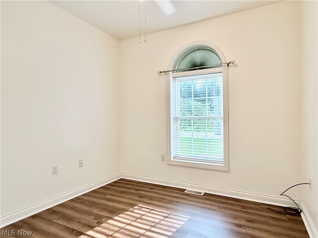 603 South Raccoon Road, Unit 1 Austintown, OH 44515 - Photo 15 of 22 Room featuring an arched window with louvered blinds, wood-finish flooring, and crisp white trim