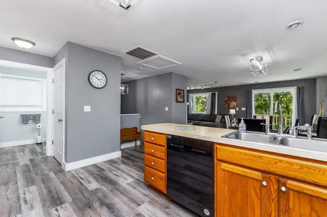 a large kitchen with stainless steel appliances granite countertop a sink and dishwasher with wooden floor