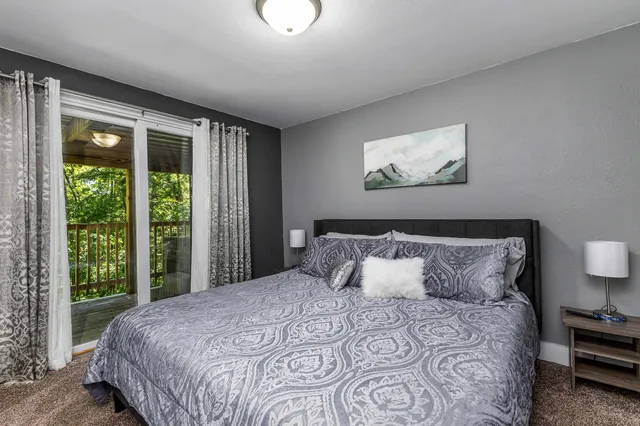 a bedroom with a large bed and a flat tv screen