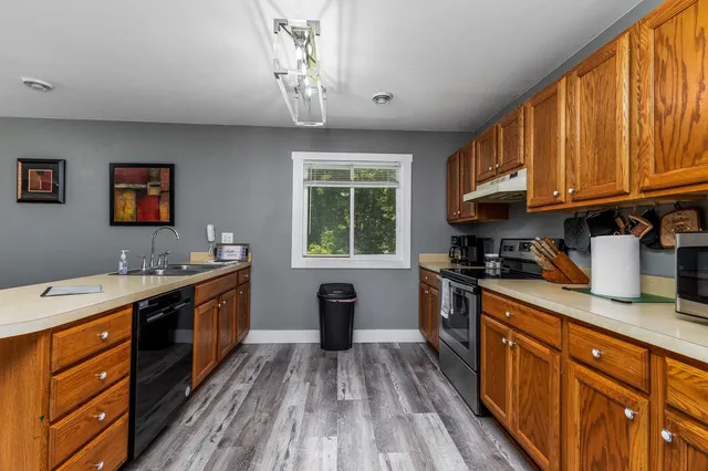 a kitchen with stainless steel appliances granite countertop a sink stove and cabinets