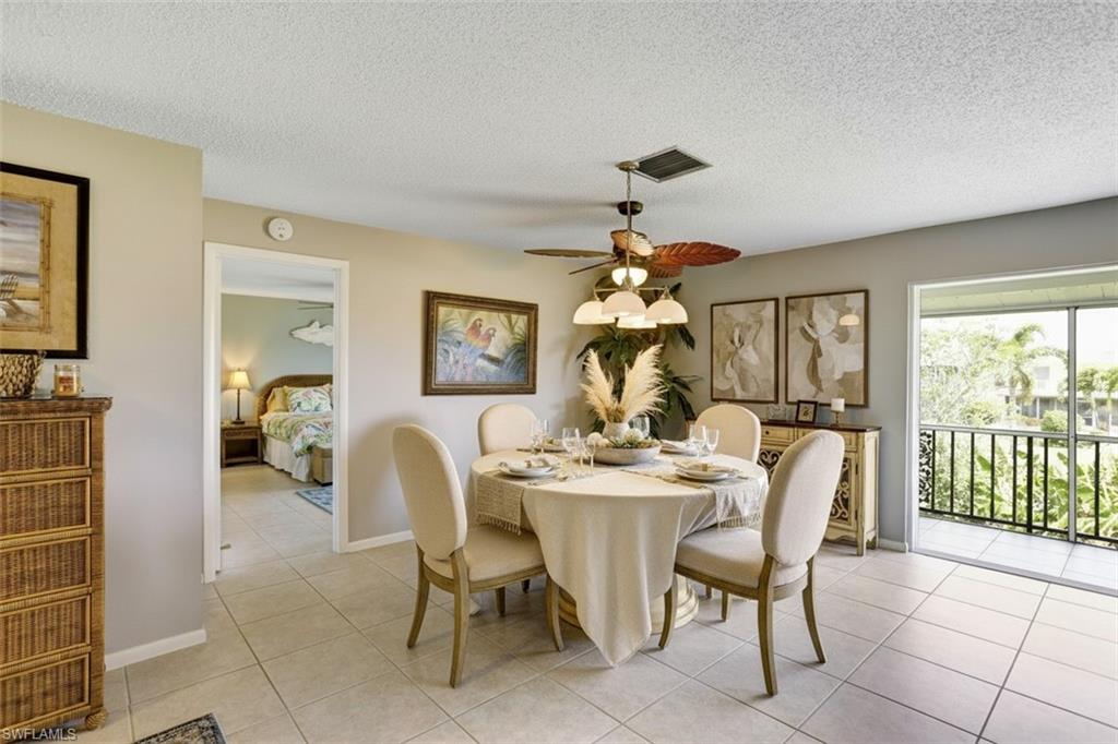 355 Palm Drive, Unit 732 Naples, FL 34112 - Photo 11 of 50 355-Palm-Dr-732-Naples-FL-Dining space partial virtual staged featuring a ceiling fan, a textured ceiling, and light tile patterned floors