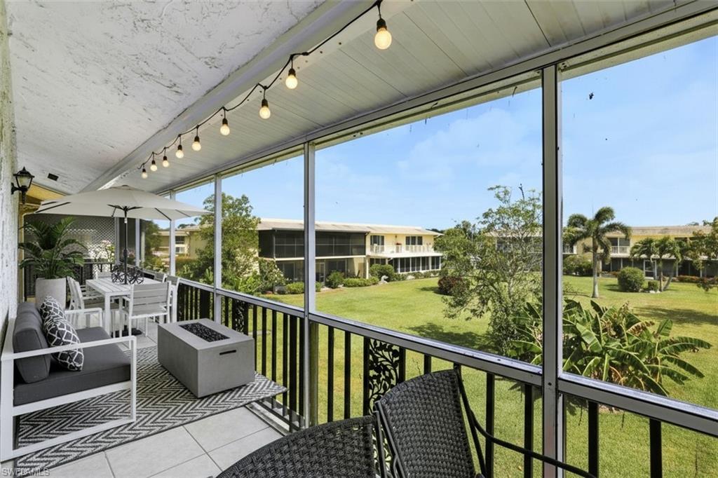 355 Palm Drive, Unit 732 Naples, FL 34112 - Photo 31 of 50 screened virtual staged balcony featuring a balcony, an outdoor fire pit, and outdoor dining area