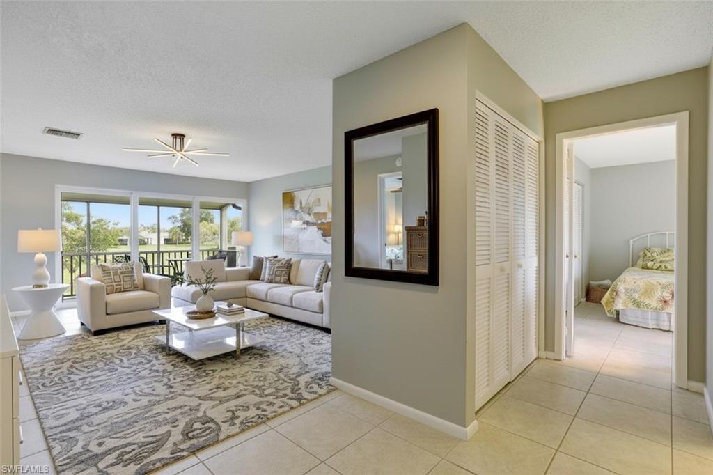 355 Palm Drive, Unit 732 Naples, FL 34112 - Photo 4 of 50 355-Palm-Dr-732-Naples-FL- entry area - virtual staged- with a textured ceiling, light tile patterned floors, and a ceiling fan