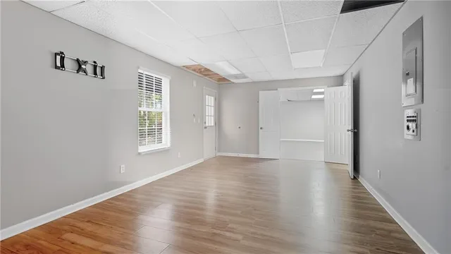 a view of an empty room with wooden floor and a window