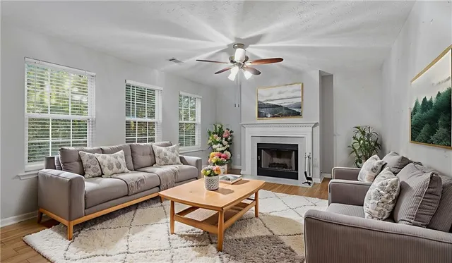 a living room with furniture a fireplace and a large window