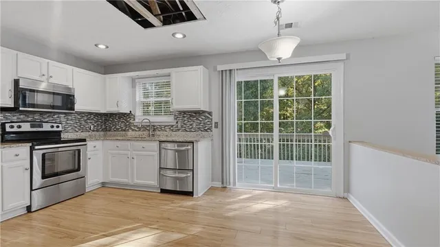 a kitchen with granite countertop a stove a sink and a microwave