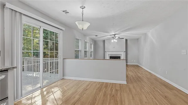 a view of empty room with wooden floor and fireplace