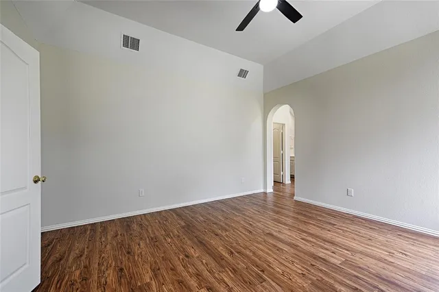 an empty room with ceiling fan and window