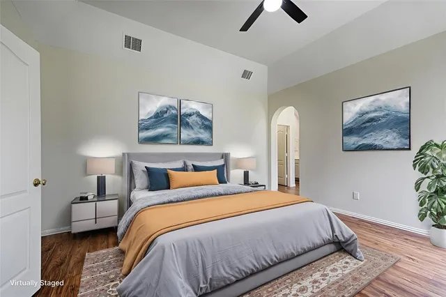 a bedroom with a bed and painting on the wall