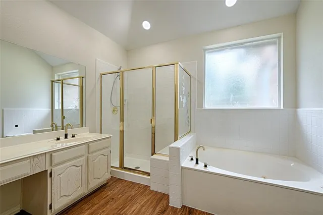 a bathroom with a tub a sink and a window