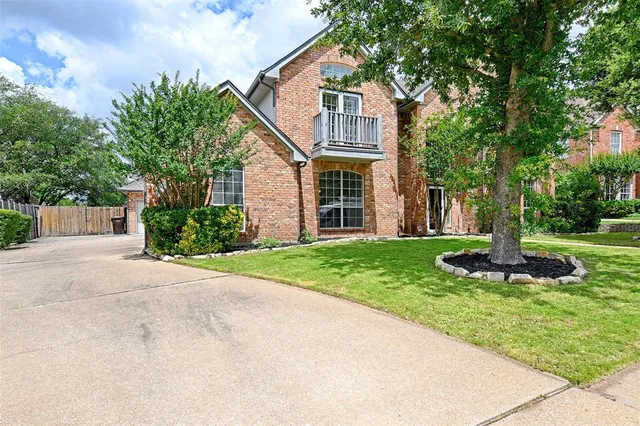 a front view of a house with a yard and trees