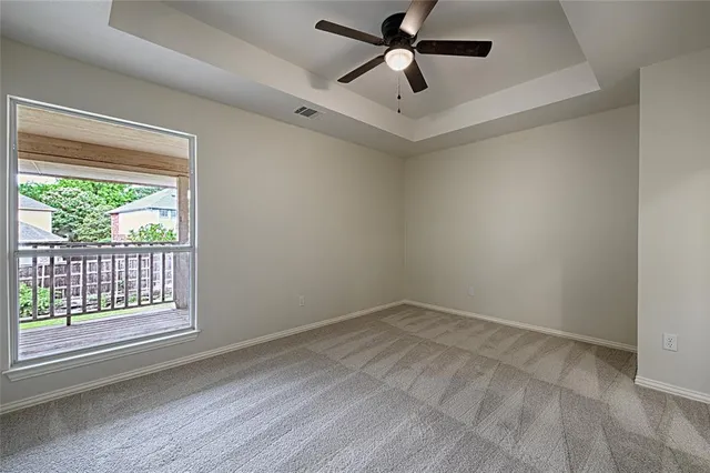 an empty room with a window and a ceiling fan