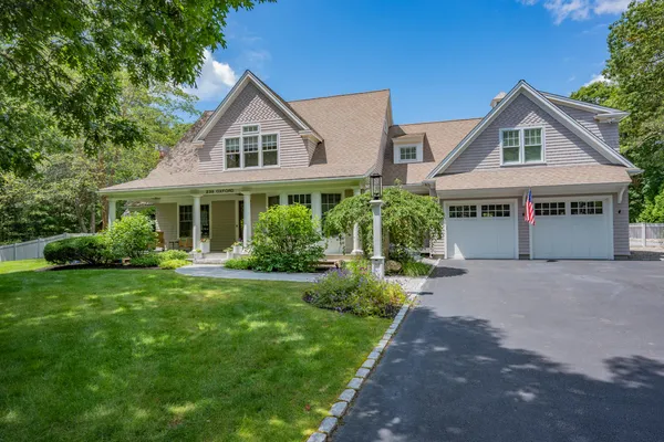 a front view of a house with a yard and potted plants