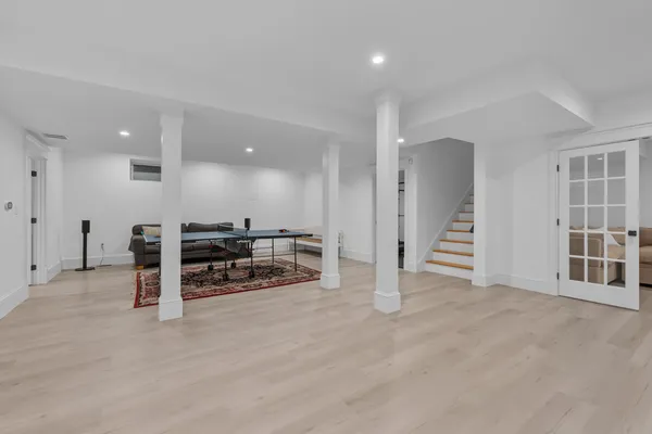 a kitchen with stainless steel appliances granite countertop a stove top oven a dining table and chairs with wooden floor