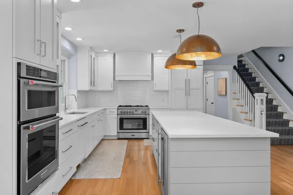 a kitchen with stainless steel appliances kitchen island granite countertop a stove a sink and a microwave