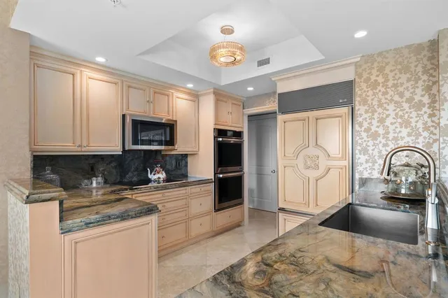 a kitchen with stainless steel appliances granite countertop a stove a sink and a microwave