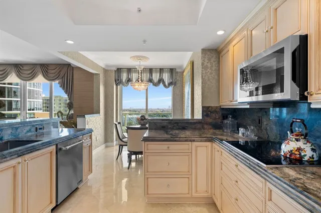 a kitchen with stainless steel appliances granite countertop a stove a sink and a microwave